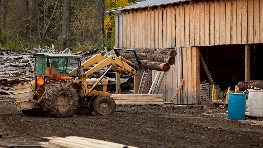 Luke lifting logs with a tractor 