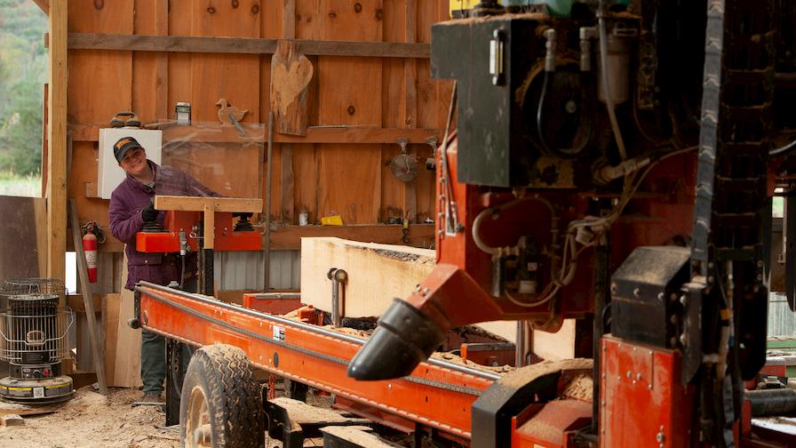 Megan sawing lumber on Wood-Mizer LT70 portable sawmill 